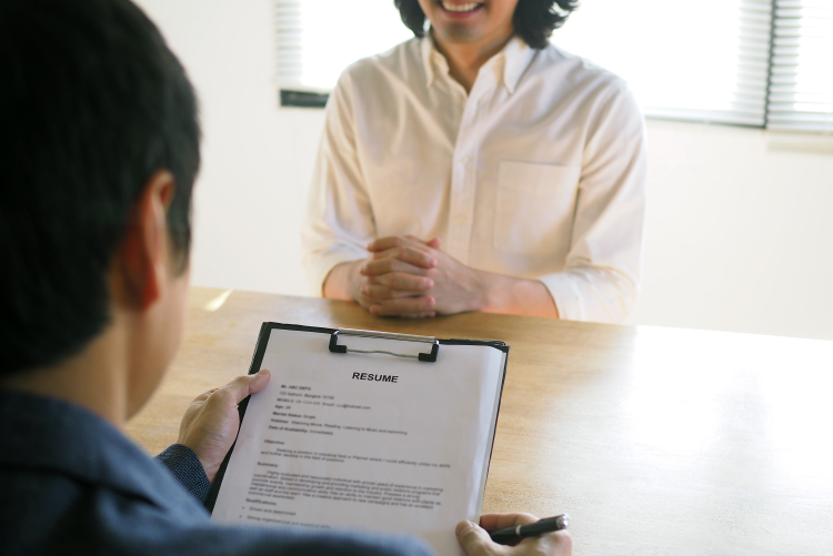 A candidate holding a resume during a job interview for a HandyDART driver position.