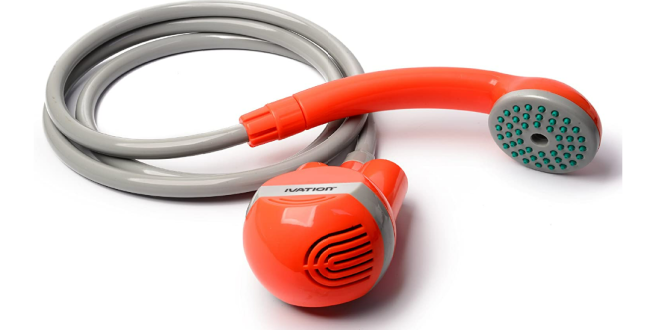 A portable outdoor shower head and orange pump unit with a grey hose, resting on a white surface.