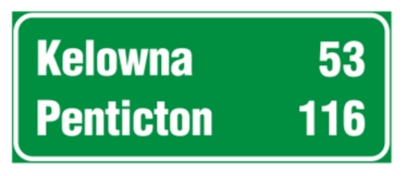 A rectangular green informational sign showing distances to various destinations.