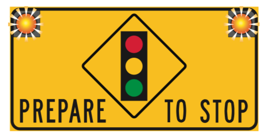 A rectangular yellow warning sign with a central diamond-shaped graphic of a traffic light; the words PREPARE and TO STOP are printed on either side of the diamond.