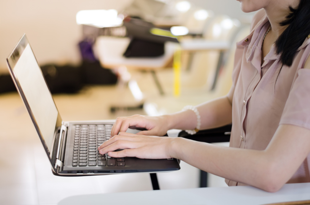 a woman typing on a laptop
