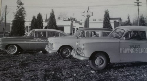 black and white photo of 3 cars from the 50's parked side by side. Each car has Valley Driving School painted on the driver's side door.
