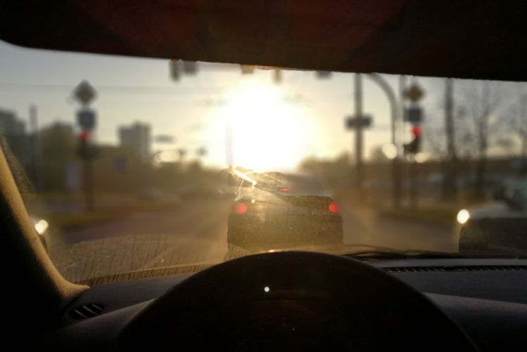 A driver's point-of-view as blinding sunlight streams through the windshield.